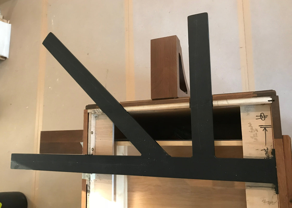 A Black Custom Support Bracket in a ‘K’ shape on a dark brown wooden countertop.