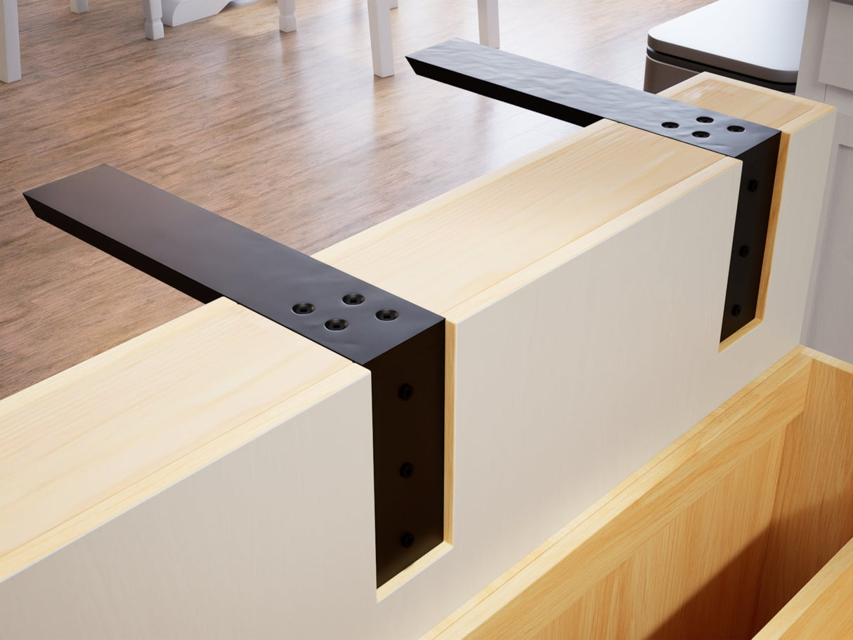 Two black L brackets mounted over a knee wall with a wooden floor in the background.