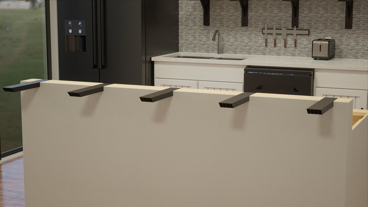 5 black Industrial L Countertop Support Brackets affixed to a beige island with a black refrigerator and a white countertop in the background.